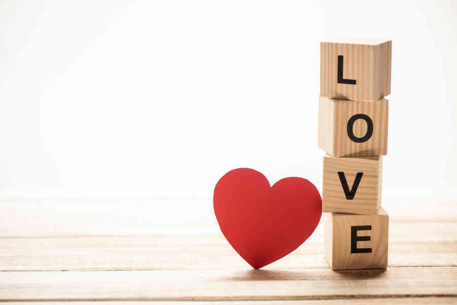 Love and relationships concept shown as a heart with some wooden blocks spelling out the word love